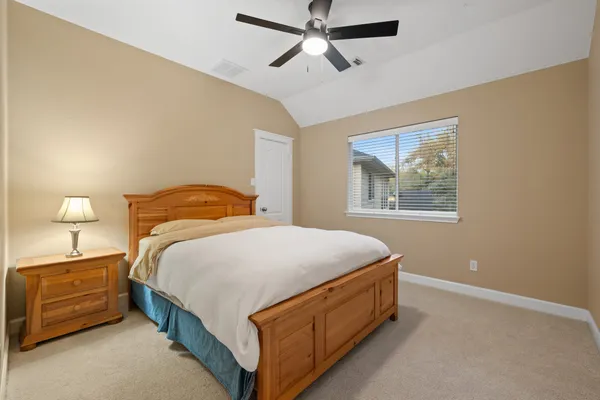 a bedroom with a bed and a lamp on the dresser