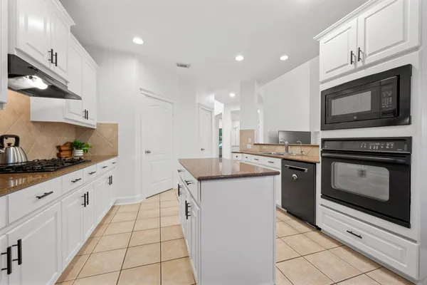 a kitchen with granite countertop a sink stove and cabinets