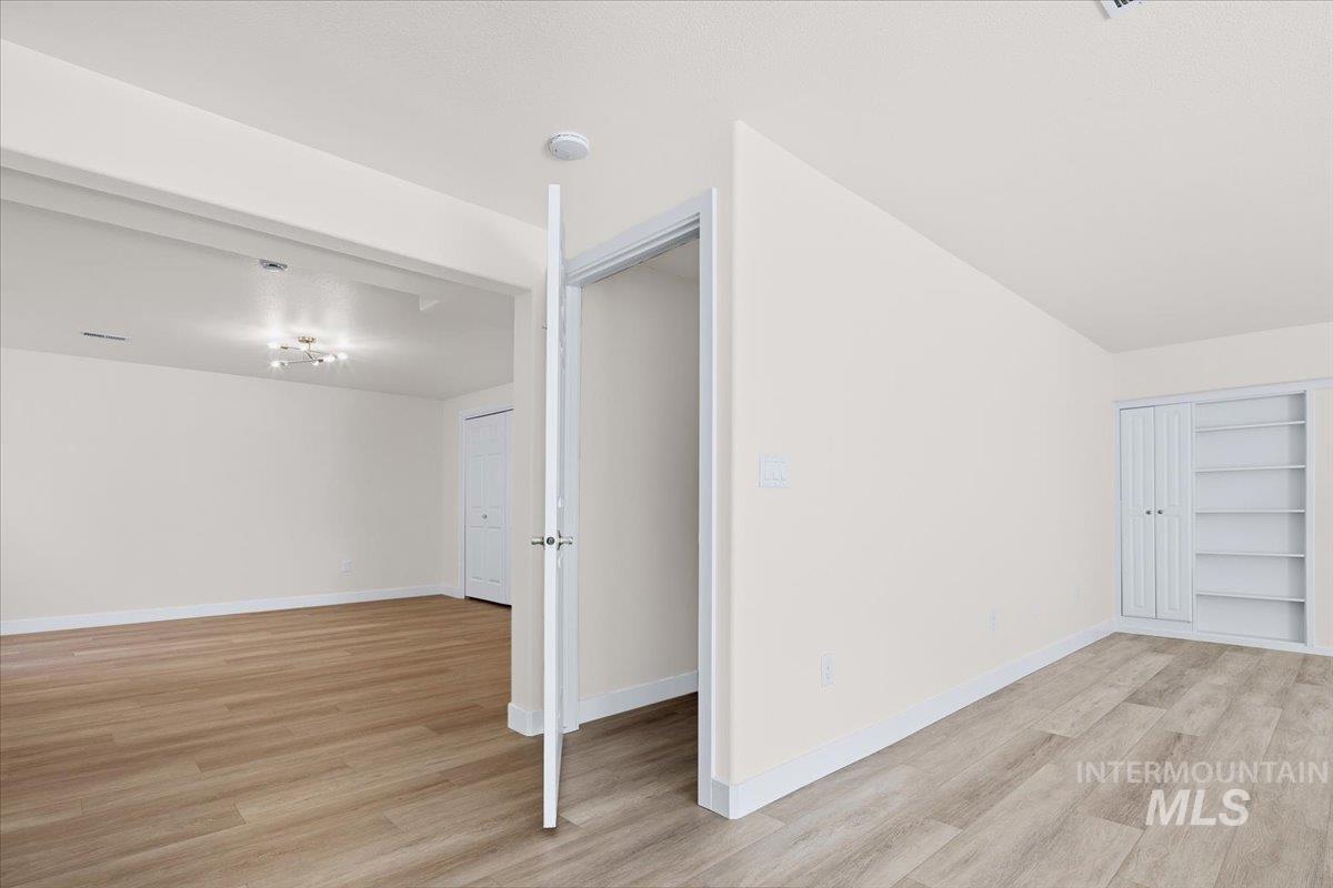 725 North Eagle Road Eagle, ID 83616 - Photo 30 of 45 Interconnected living spaces featuring wood-finish flooring, a contemporary ceiling light fixture, and built-in shelving with bifold doors
