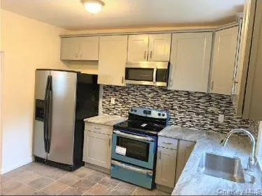 a kitchen with a stove a sink and a refrigerator