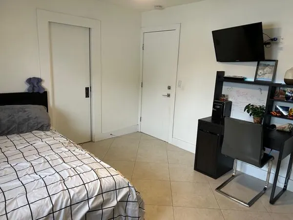 a bedroom with a bed and a potted plant