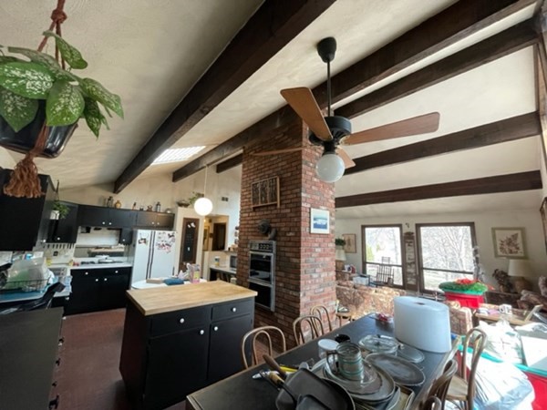 6 Beaver Place Billerica, MA 01821 - Photo 11 of 25 a open kitchen with stainless steel appliances kitchen island granite countertop a sink dishwasher and a fireplace with wooden floor
