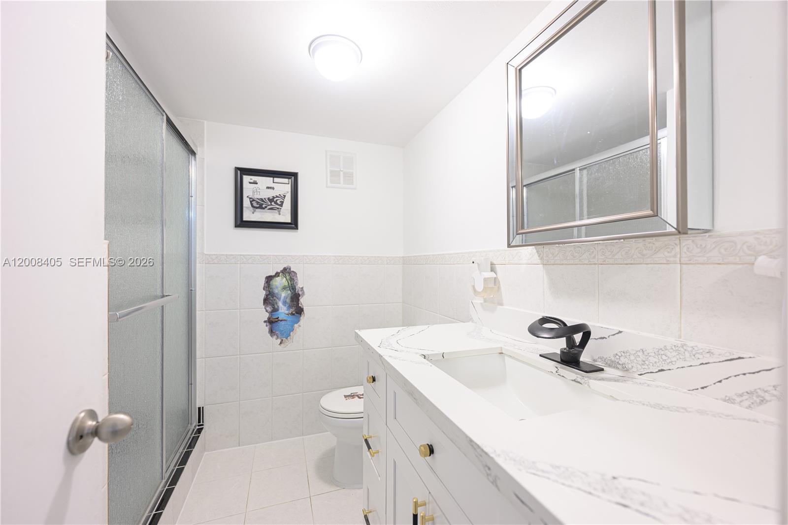 6195 Rock Island Road, Unit 503 Tamarac, FL 33319 - Photo 18 of 29 a bathroom with a sink and mirror with toilet