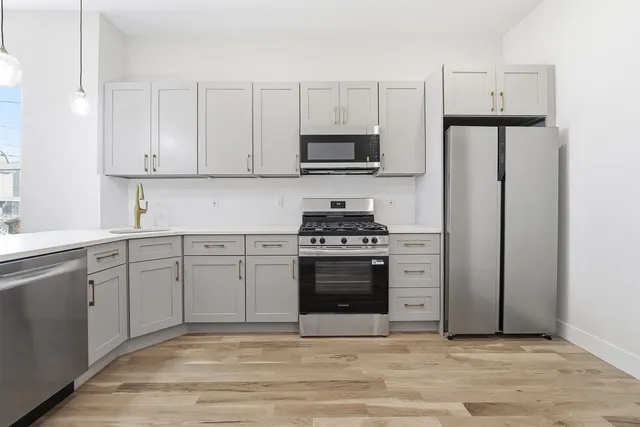 a kitchen with stainless steel appliances granite countertop a refrigerator stove a sink and a microwave