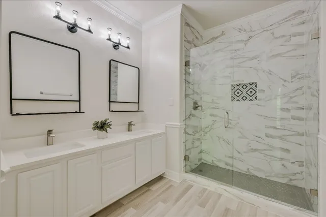 a bathroom with a double vanity sink mirror and shower