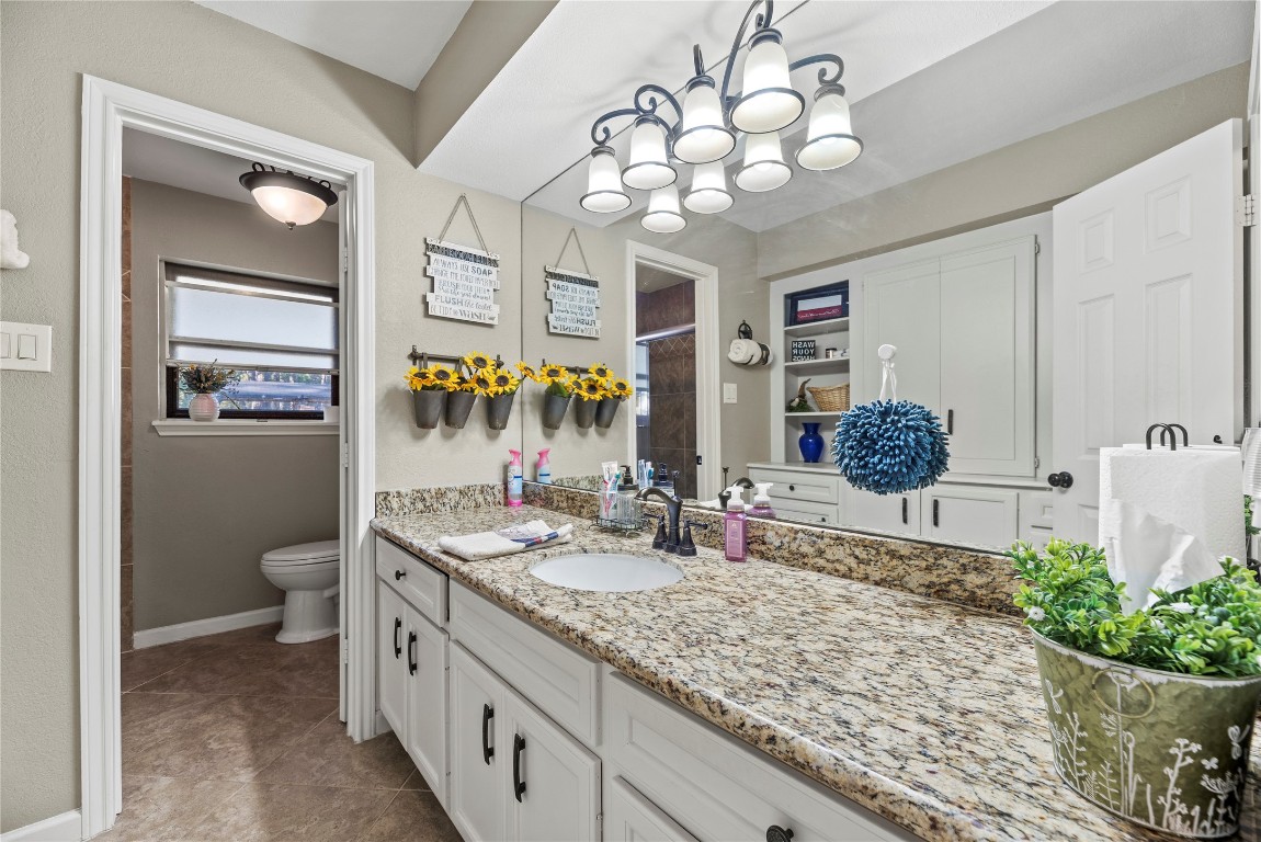 1203 Lemm Road 2 Spring, TX 77373 - Photo 13 of 21 This well-appointed secondary bathroom features durable granite countertops and a large double sink vanity, enhanced by tile flooring, ample built-in cabinetry for storage, and a tub/shower combo in the separate commode area.