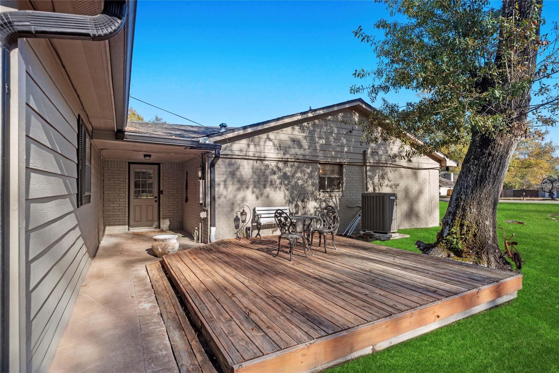 1203 Lemm Road 2 Spring, TX 77373 - Photo 18 of 21 Located on the side of the home, this space overlooks the manicured lawn and mature trees of the sprawling corner lot. The inviting raised wood deck provides a secondary outdoor seating area, perfect for enjoying a quiet morning coffee.