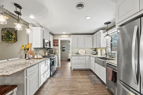 a kitchen with stainless steel appliances granite countertop refrigerator a sink and dishwasher