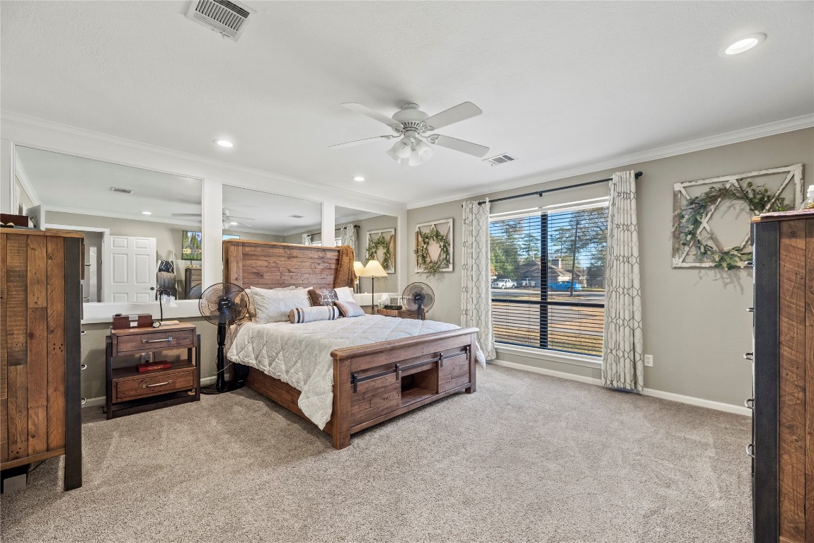 1203 Lemm Road 2 Spring, TX 77373 - Photo 9 of 21 The spacious primary suite is a restful haven featuring plush carpet, a walk-in closet, and a unique mirrored feature wall for added depth.