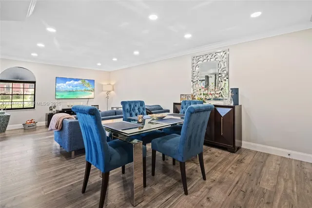 a view of a a dining room with furniture window and wooden floor