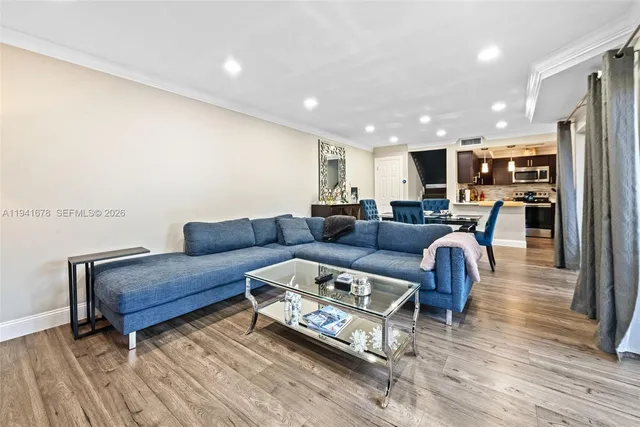 a living room with furniture and a wooden floor