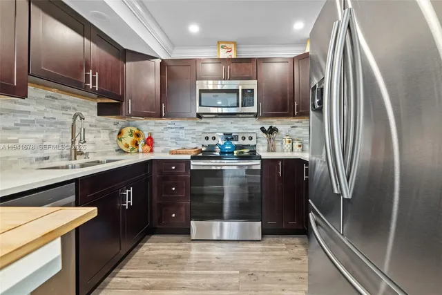 a kitchen with stainless steel appliances granite countertop a refrigerator and a sink