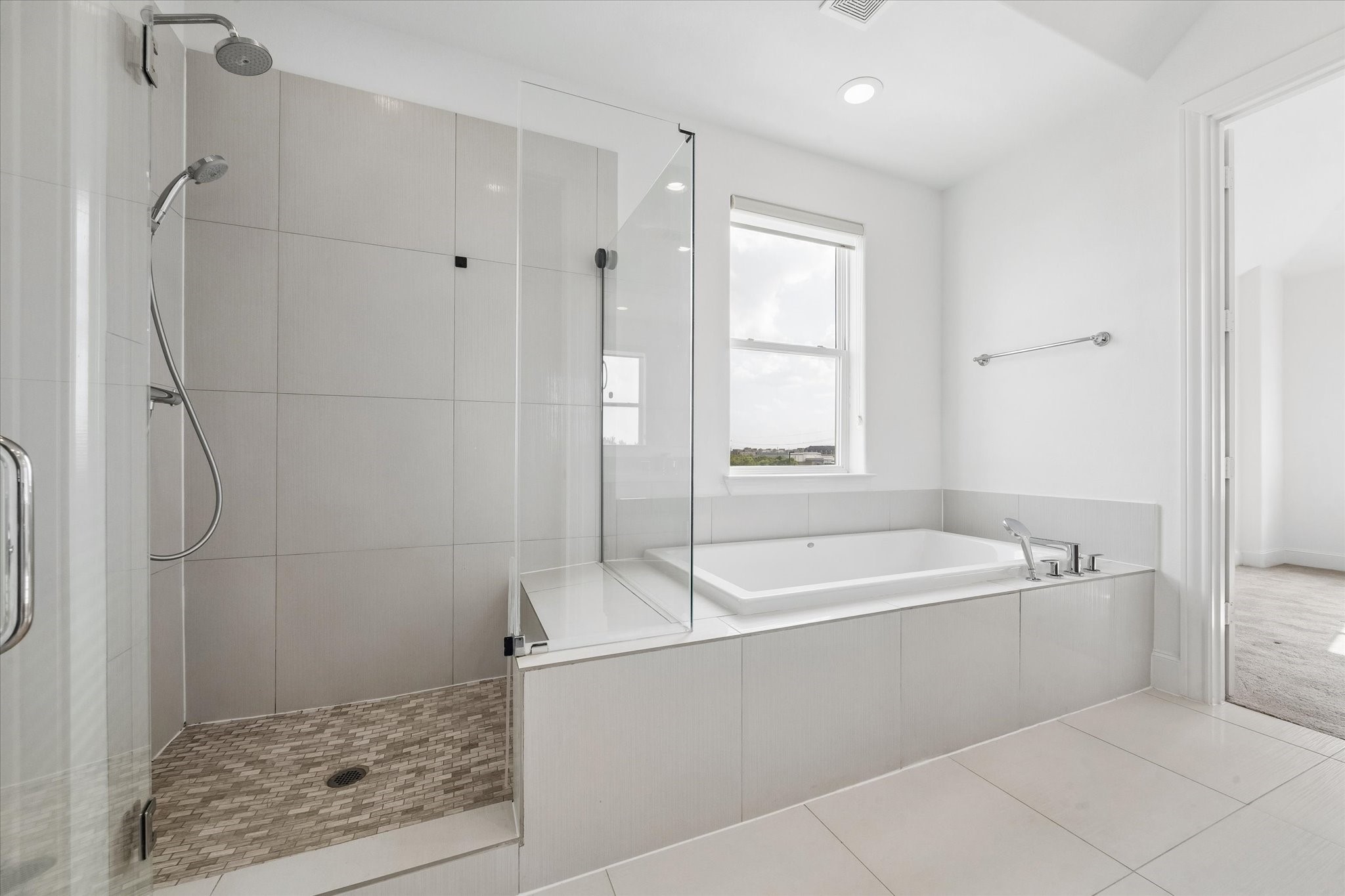 2024 Waterloo Station Road Houston, TX 77045 - Photo 14 of 19 Oversized glass enclosed stand up shower (with a seat) & tub to relax in after a long day at work.