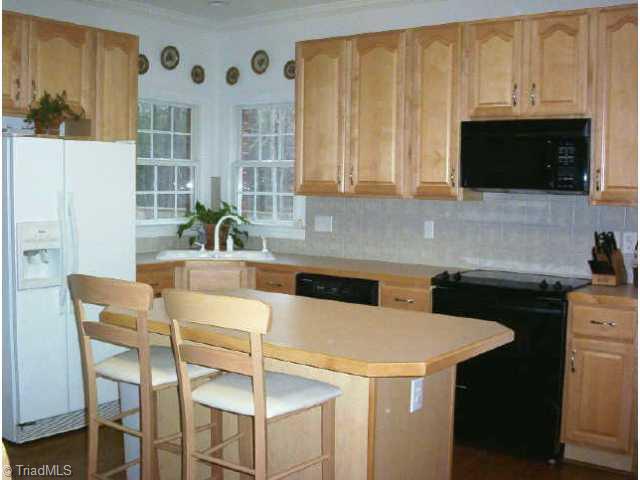 1806 Ridge Oaks Drive Oak Ridge, NC 27310 - Photo 5 of 9 Other. The kitchen is open to the breakfast area and family room. There is a island, two pantries, smooth top stove, built in microwave and dishwasher. There is a pre-wire for a disposal.
