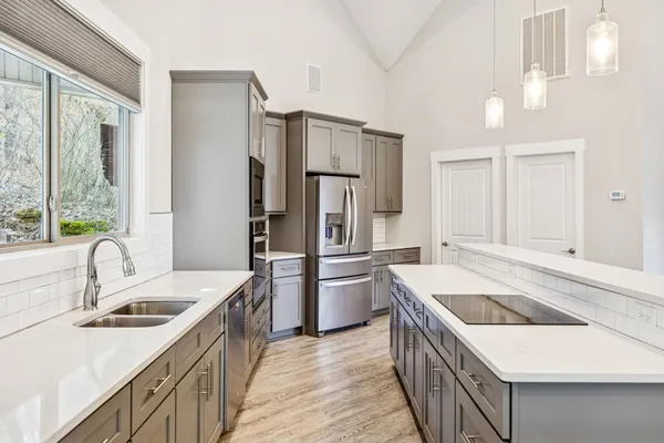 a view of a livingroom with a fireplace a chandelier and wooden floor
