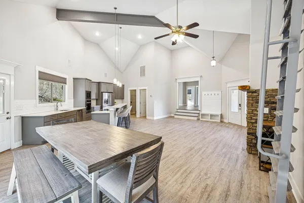 a view of a dining room and livingroom with furniture wooden floor a chandelier