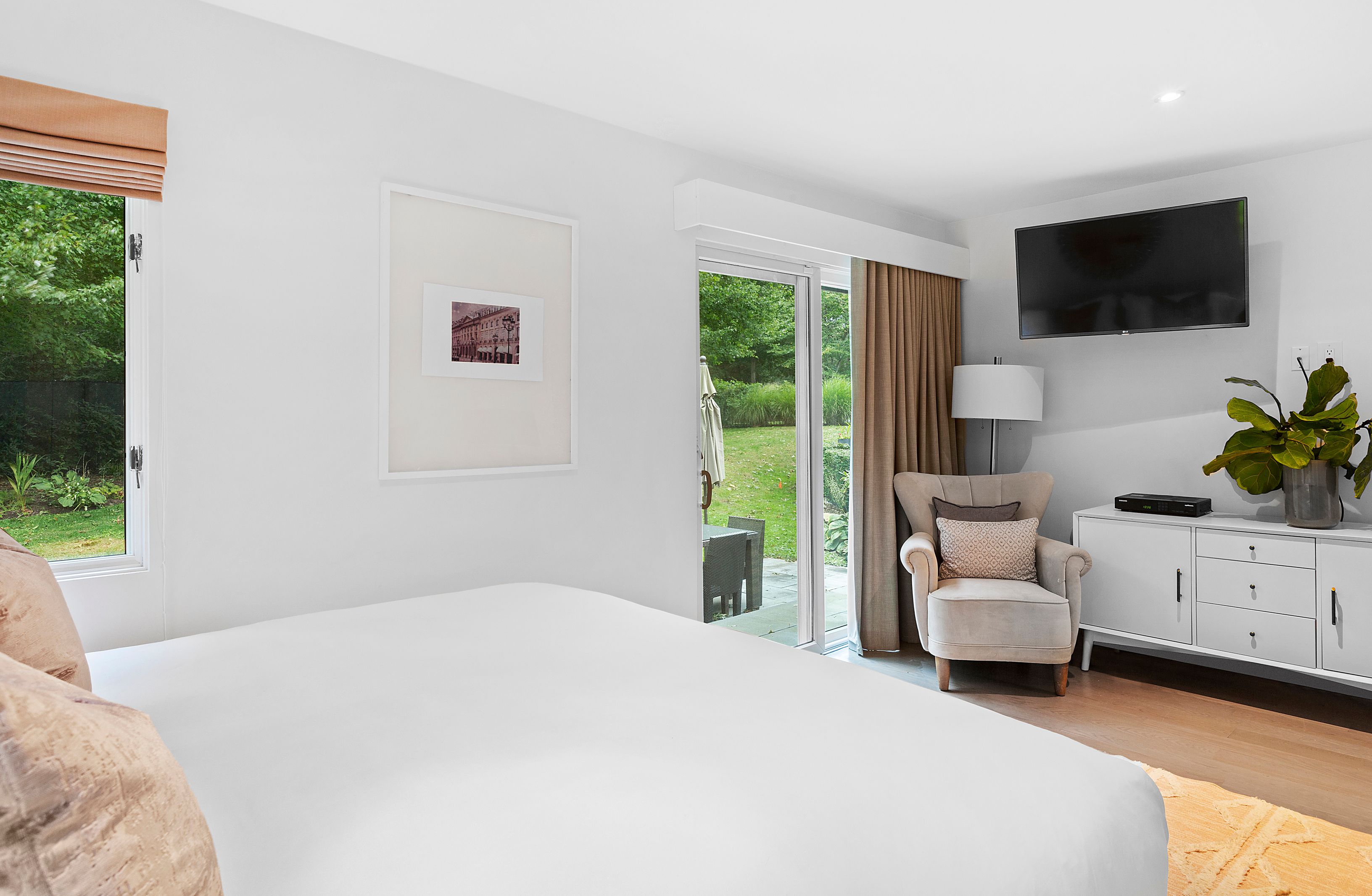 81 Neck Path East Hampton, NY 11937 - Photo 16 of 29 a bedroom with a bed a flat screen tv and a couch