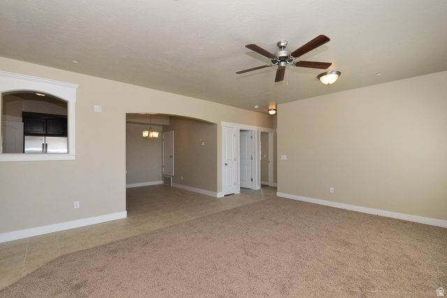 241 West Ridge Road Saratoga Springs, UT 84045 - Photo 2 of 21 Spacious living area featuring carpet flooring, a ceiling fan with integrated lighting, and an arched entryway