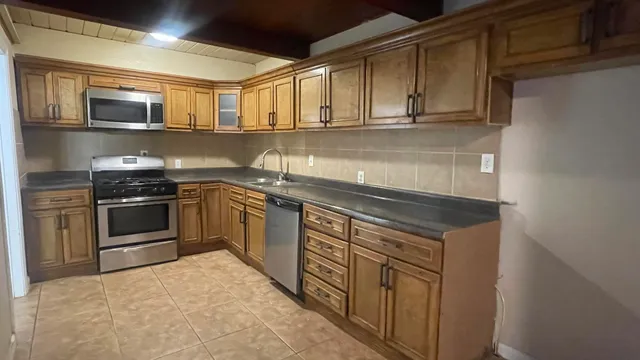 a kitchen with stainless steel appliances granite countertop a sink and stove top oven
