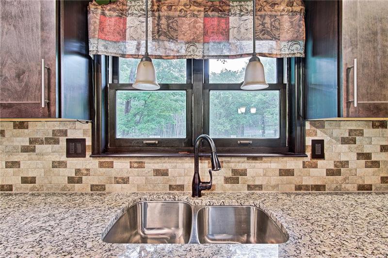 112 Wycliffe Way Butler, PA 16001 - Photo 4 of 24 More of the beautiful granite countertops, double bowl sink, and oil rubbed bronze faucet. View into the back yard.