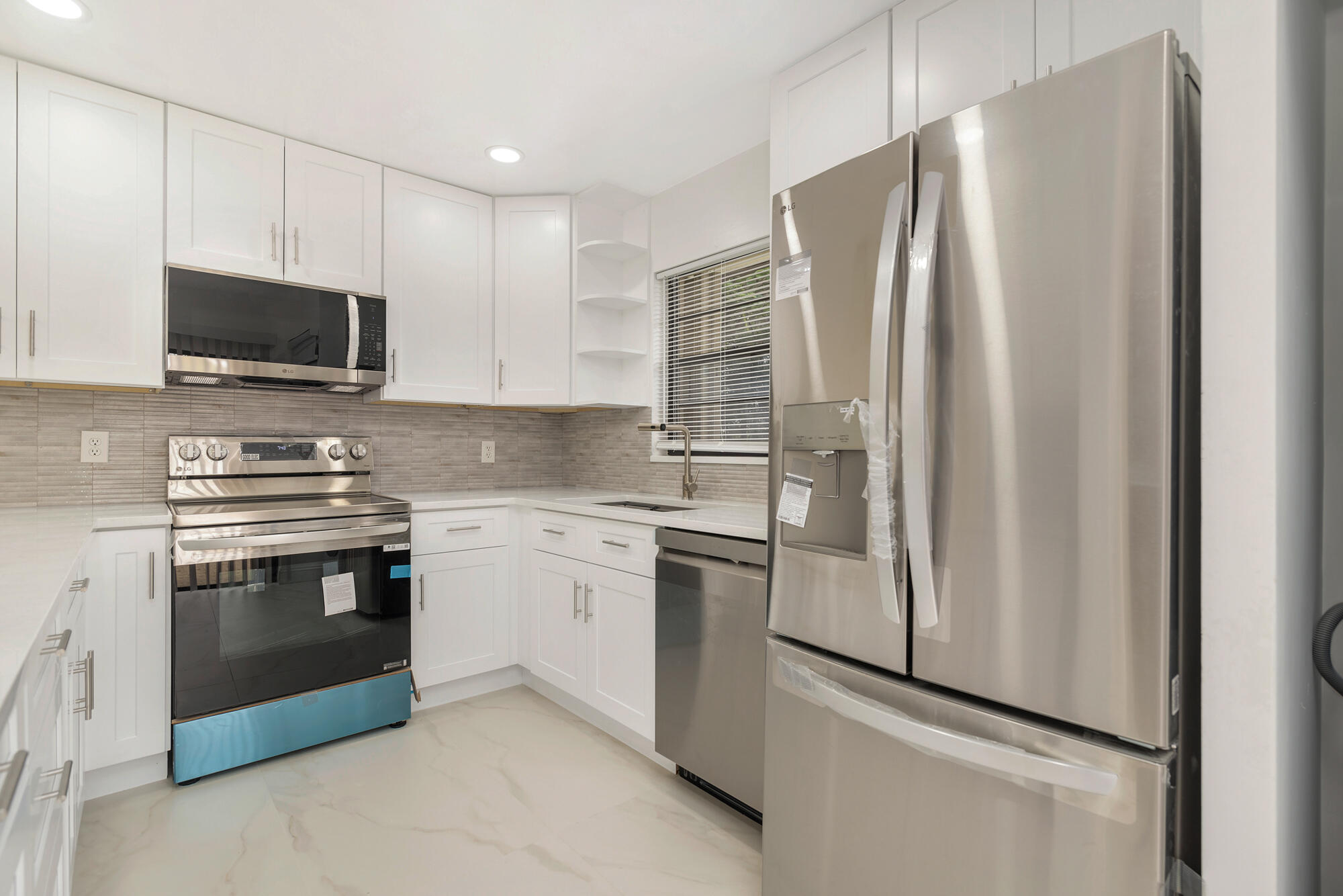 326 Jupiter Lakes Boulevard, Unit 2310B Jupiter, FL 33458 - Photo 12 of 48 a kitchen with stainless steel appliances a refrigerator sink and microwave