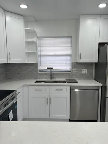a kitchen with stainless steel appliances granite countertop a stove a sink and a microwave