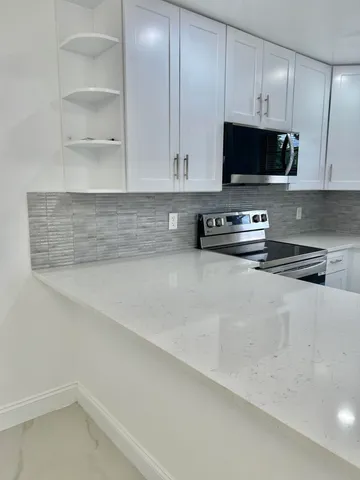 a kitchen with stainless steel appliances a stove microwave and sink