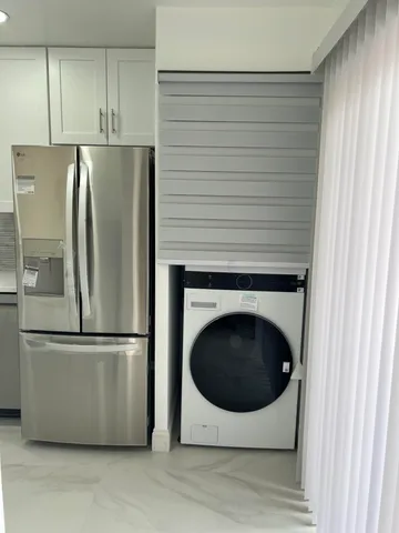 a view of a kitchen with a sink and refrigerator
