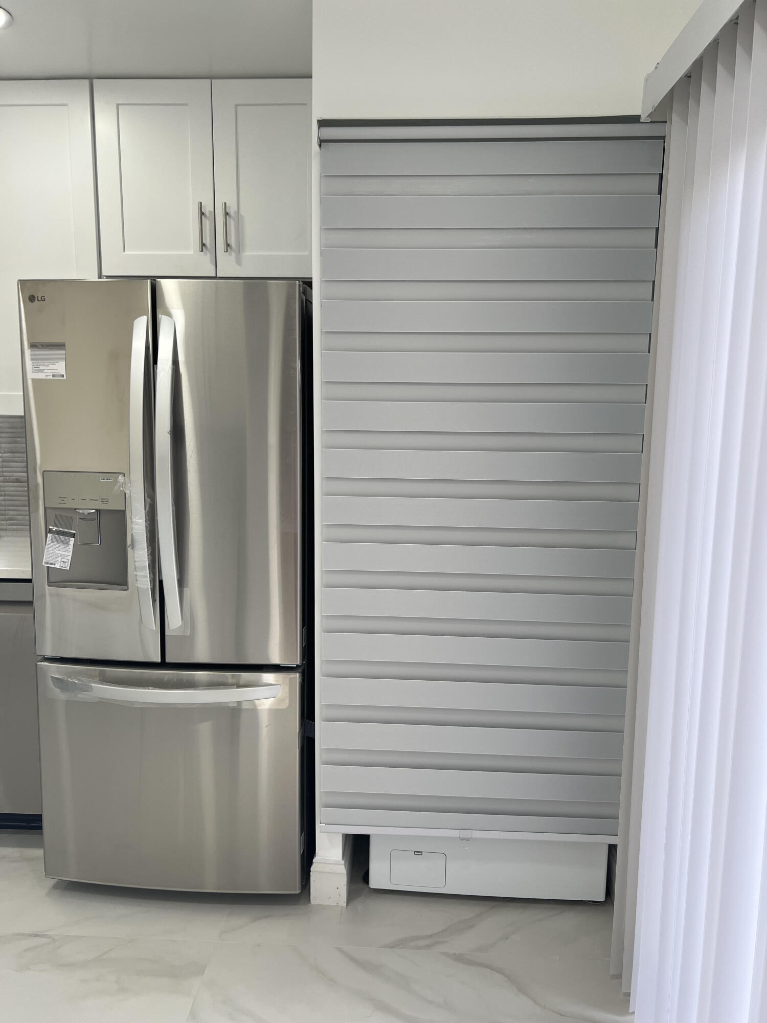 326 Jupiter Lakes Boulevard, Unit 2310B Jupiter, FL 33458 - Photo 22 of 48 a kitchen with refrigerator and white cabinets