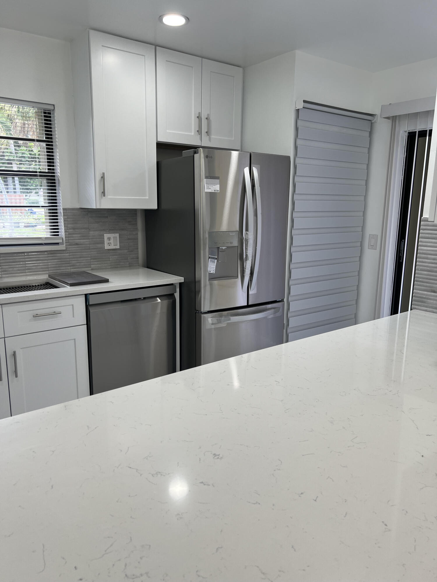 326 Jupiter Lakes Boulevard, Unit 2310B Jupiter, FL 33458 - Photo 23 of 48 a kitchen with stainless steel appliances kitchen island a refrigerator sink and cabinets