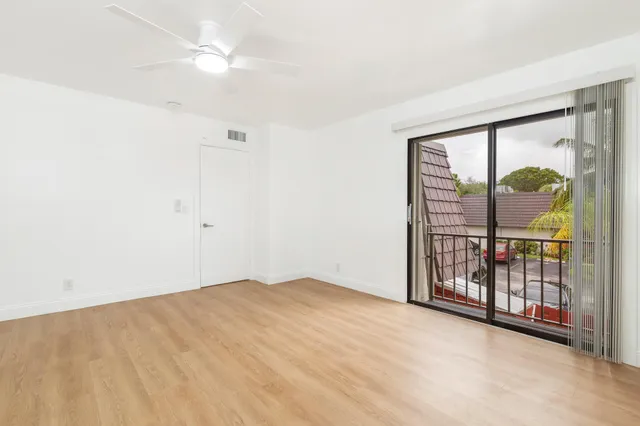 an empty room with windows and fan