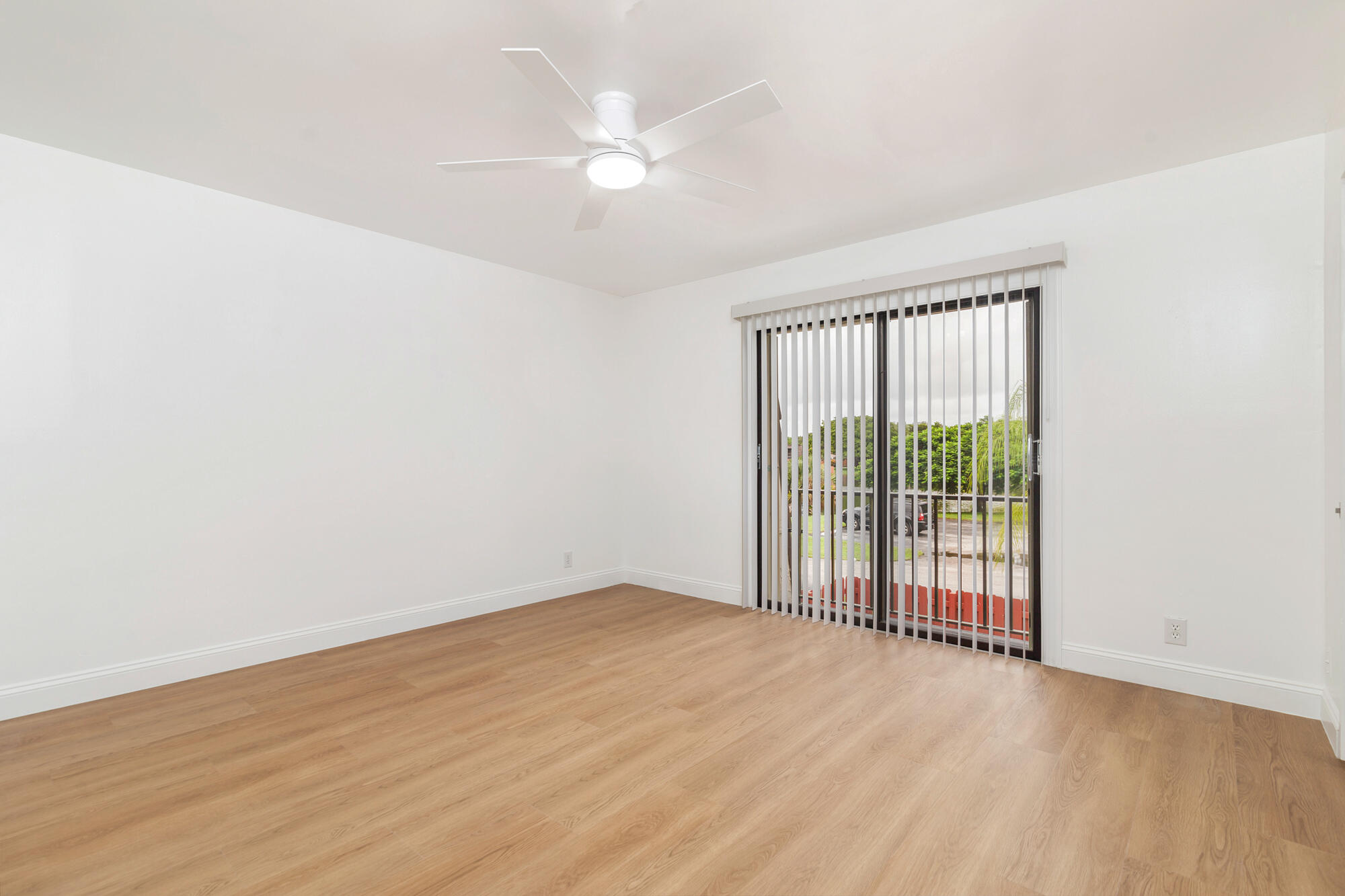 326 Jupiter Lakes Boulevard, Unit 2310B Jupiter, FL 33458 - Photo 30 of 48 an empty room with wooden floor and windows