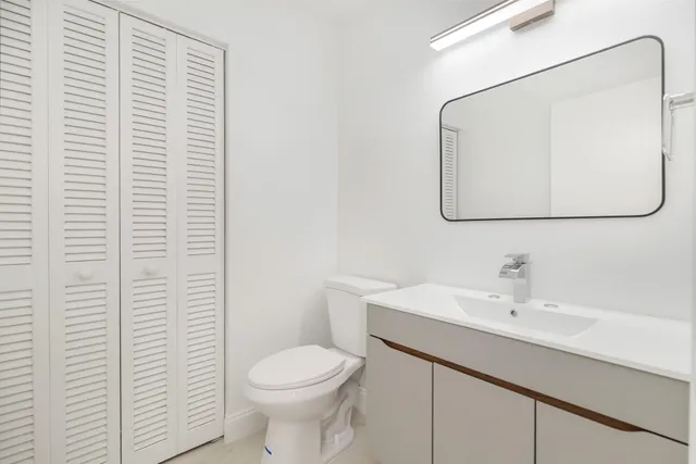 a bathroom with a sink a toilet and mirror