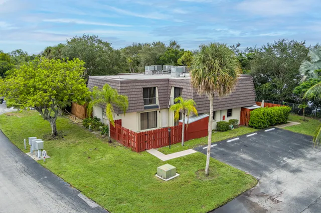 an aerial view of residential houses with outdoor space and trees