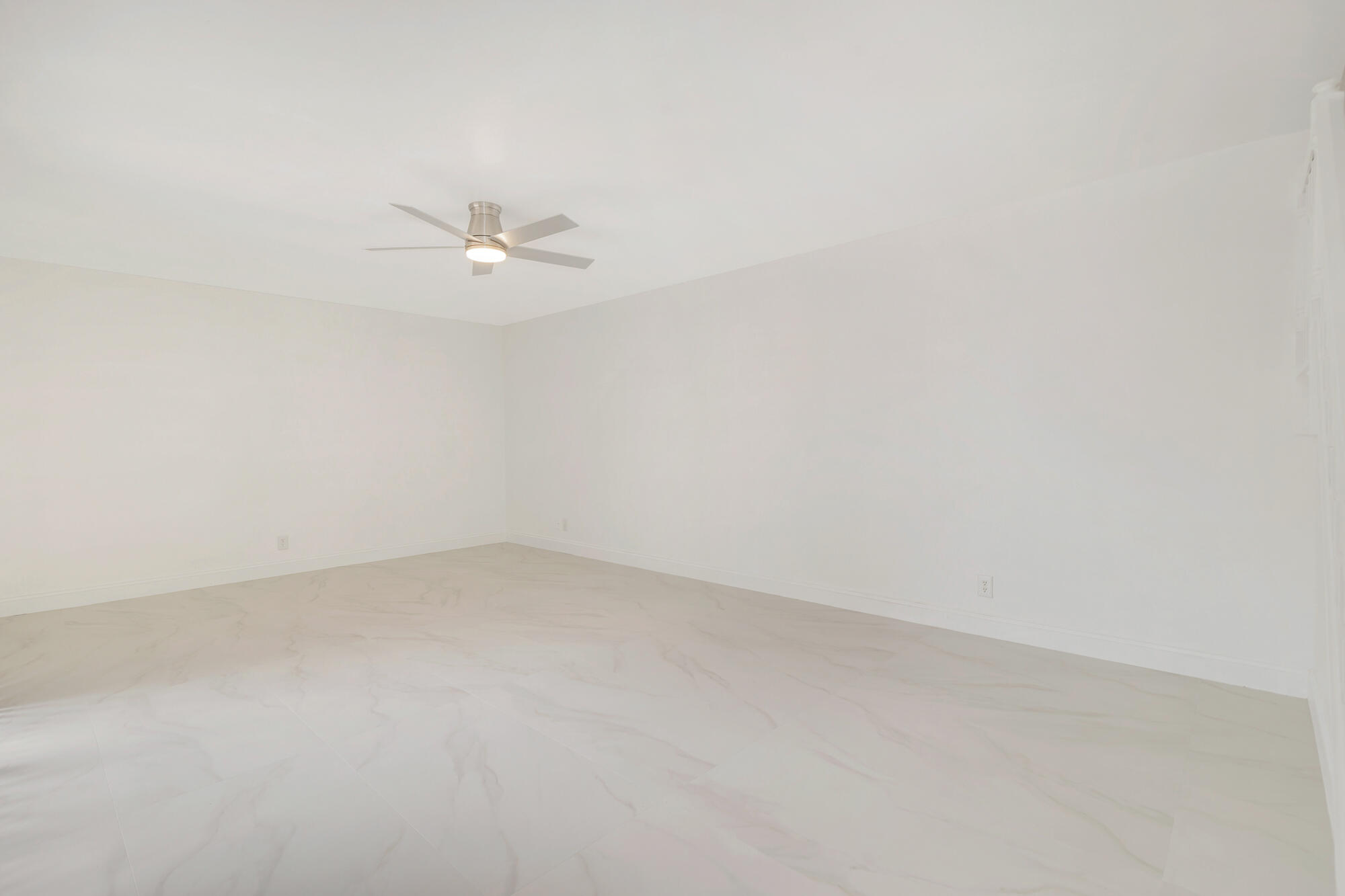 326 Jupiter Lakes Boulevard, Unit 2310B Jupiter, FL 33458 - Photo 7 of 48 an empty room with a ceiling fan and a window