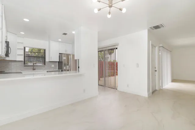 a view of large kitchen with a sink stainless steel appliances and cabinets