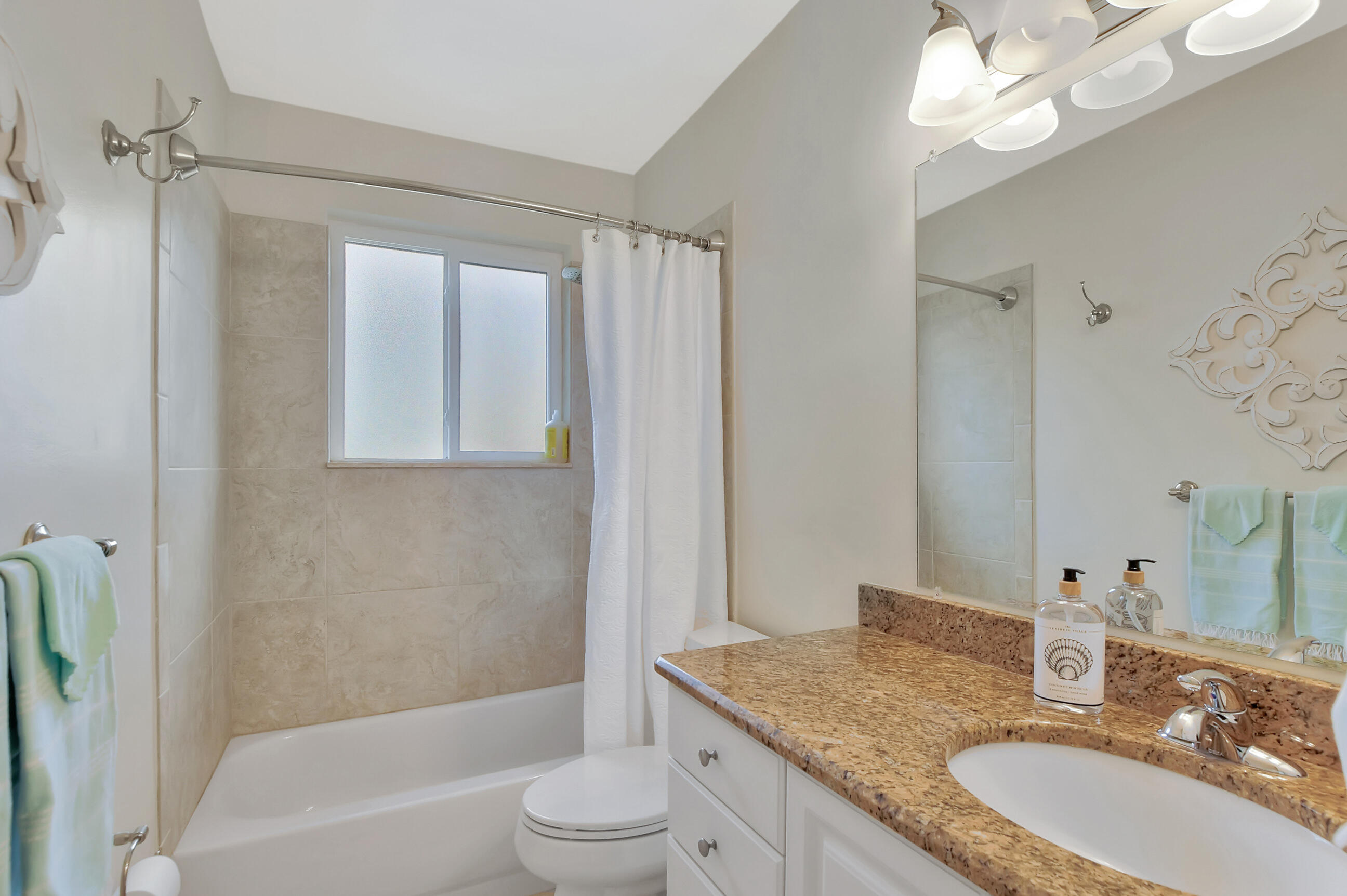 1133 Southwest 7th Street Boca Raton, FL 33486 - Photo 14 of 20 a bathroom with a granite countertop sink a toilet a mirror and shower