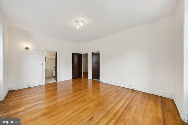 a view of an empty room with wooden floor