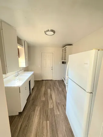 a view of a kitchen with a sink and refrigerator