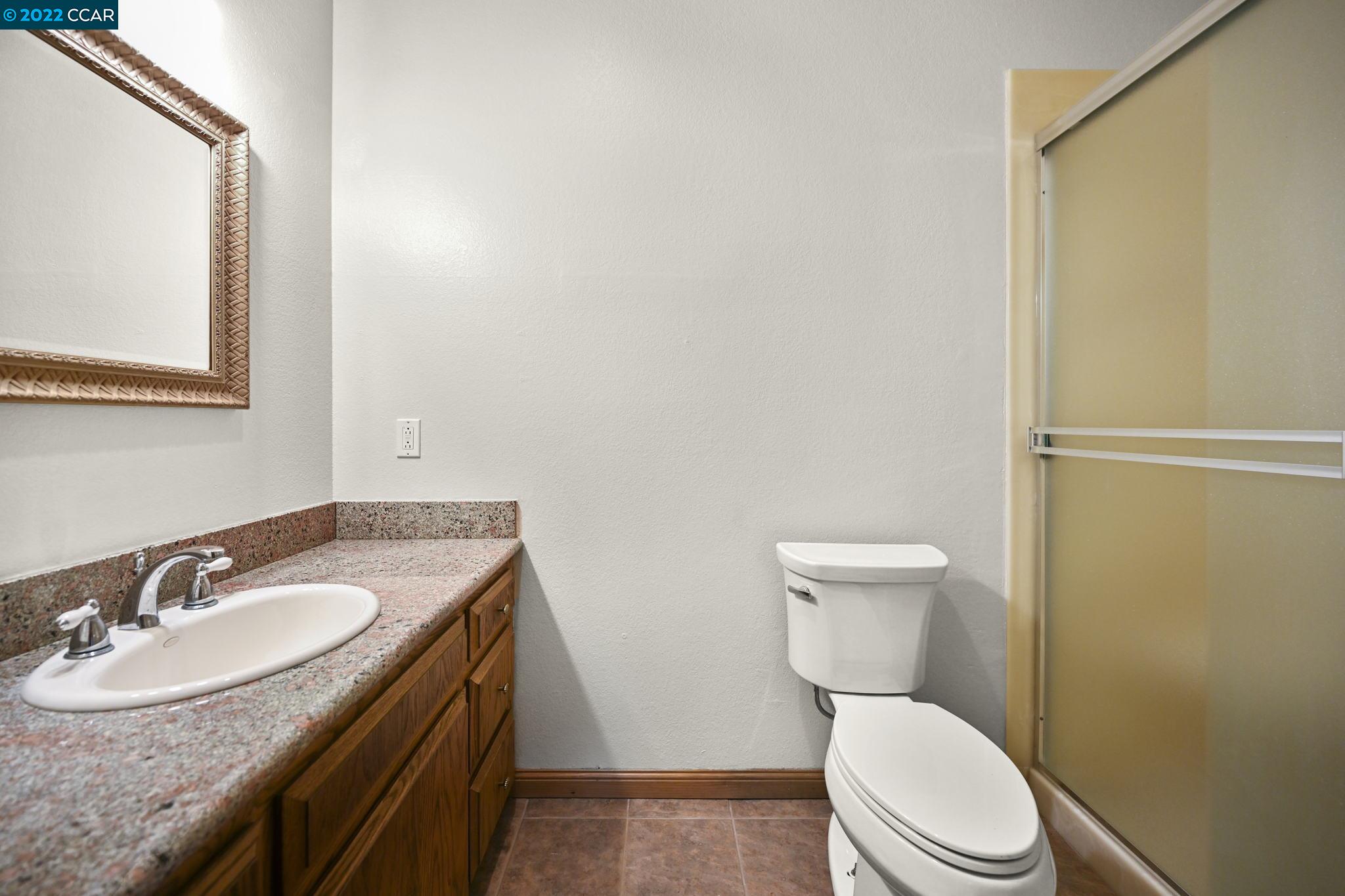 5433 Alhambra Valley Road Martinez, CA 94553 - Photo 32 of 59 a bathroom with a granite countertop toilet sink and mirror