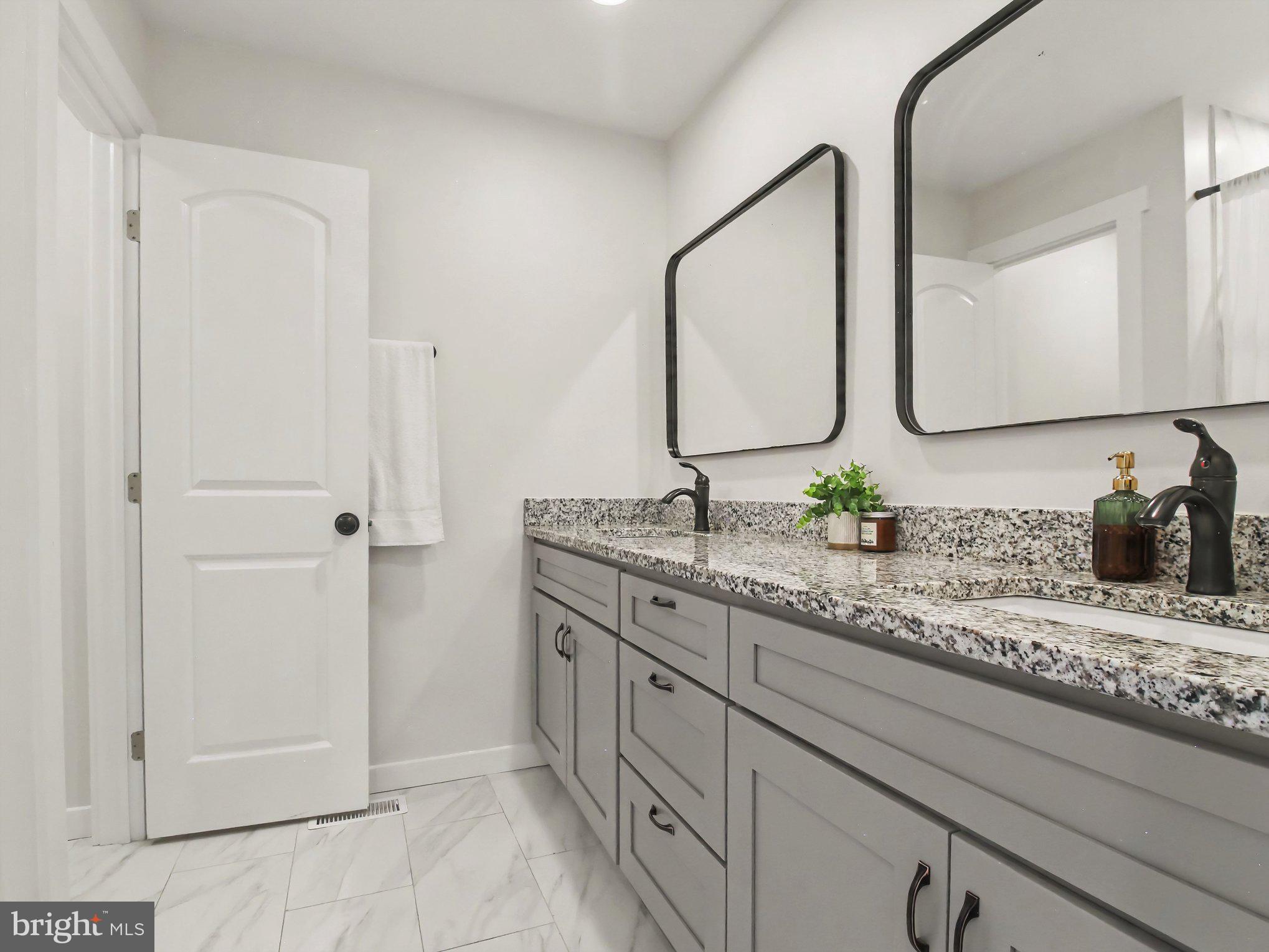 3915 Roland Avenue Baltimore, MD 21211 - Photo 16 of 26 a bathroom with a granite countertop sink and a mirror