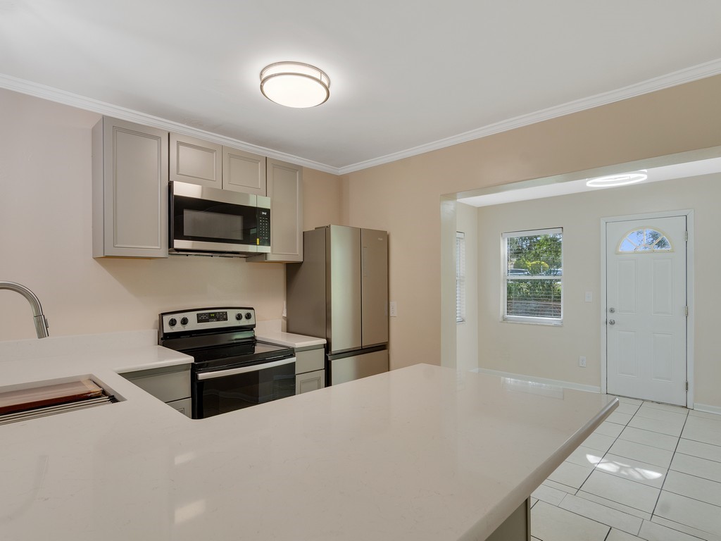 4606 30th Avenue Vero Beach, FL 32967 - Photo 14 of 33 a kitchen with stainless steel appliances a refrigerator stove and microwave