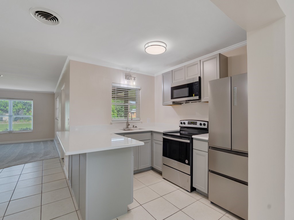 4606 30th Avenue Vero Beach, FL 32967 - Photo 16 of 33 a kitchen with stainless steel appliances granite countertop a sink and a stove