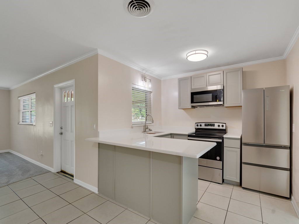 4606 30th Avenue Vero Beach, FL 32967 - Photo 17 of 33 a kitchen with stainless steel appliances a refrigerator sink and microwave