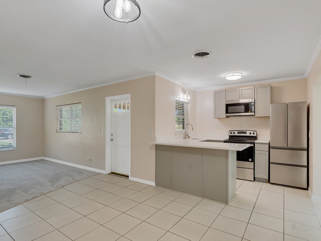 4606 30th Avenue Vero Beach, FL 32967 - Photo 8 of 33 a kitchen with stainless steel appliances granite countertop a refrigerator and a stove top oven
