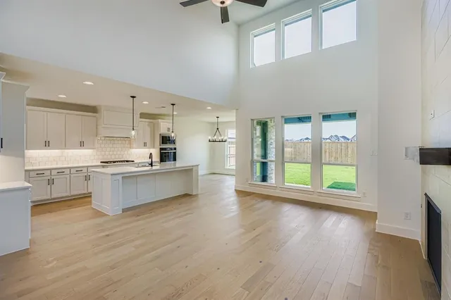a large kitchen with stainless steel appliances wooden floors and view living room