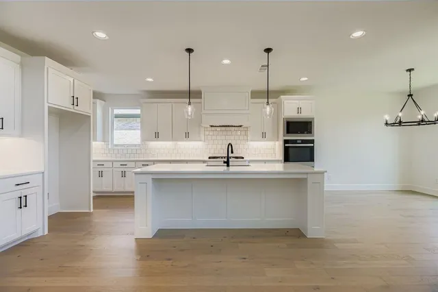 a view of a kitchen with a sink a fireplace and windows
