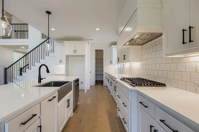 a kitchen with stainless steel appliances granite countertop a sink a stove and a refrigerator