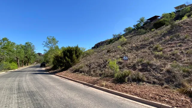 a view of a street with a wooden fence