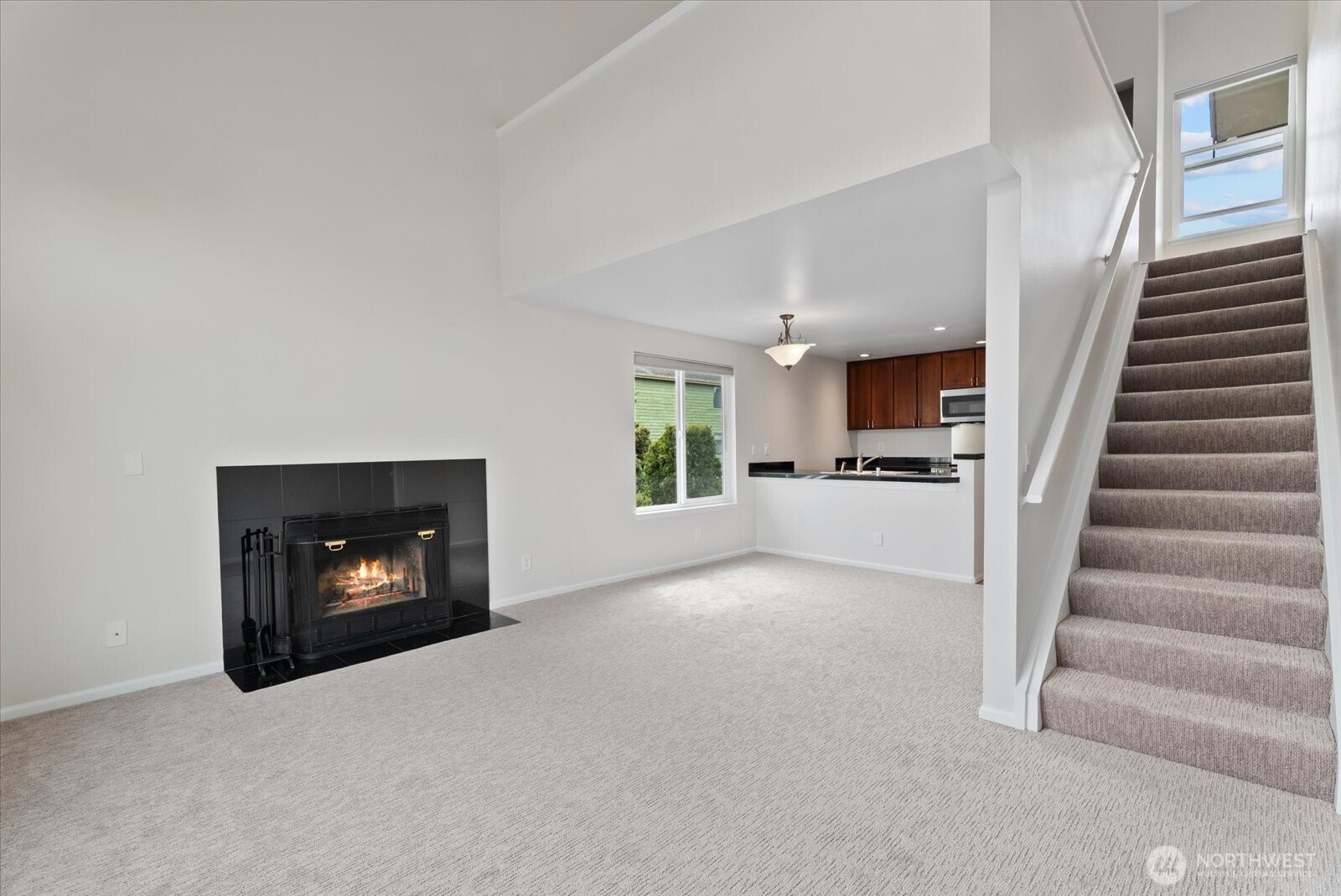 1109 North Allen Place, Unit 205 Seattle, WA 98103 - Photo 11 of 26 a view of kitchen and an empty room with fireplace